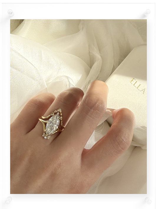 Gold engagement ring with a pear-shaped diamond on a white background