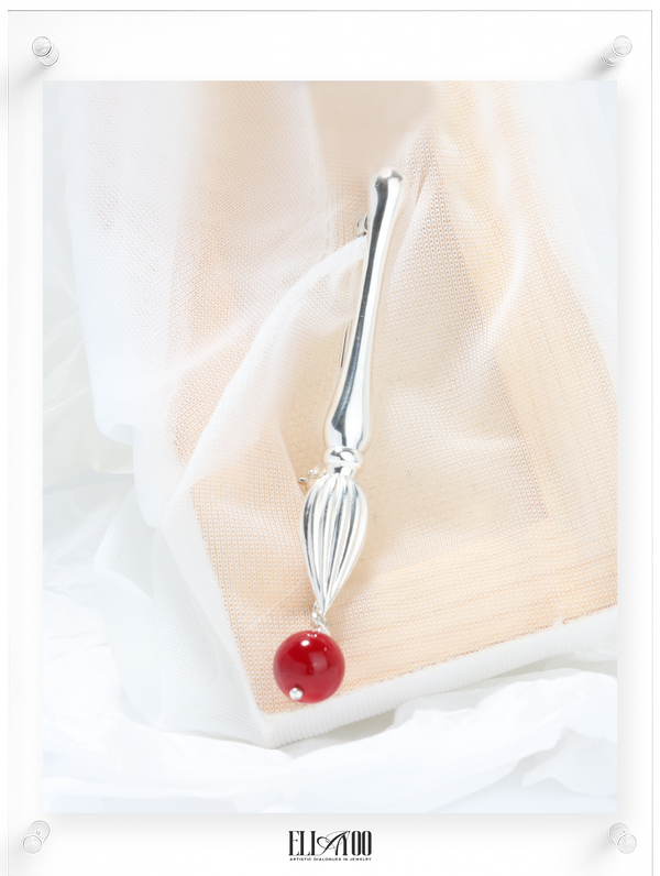Front view of Silver brooch featuring a paint brush shape with a Coral Sphere