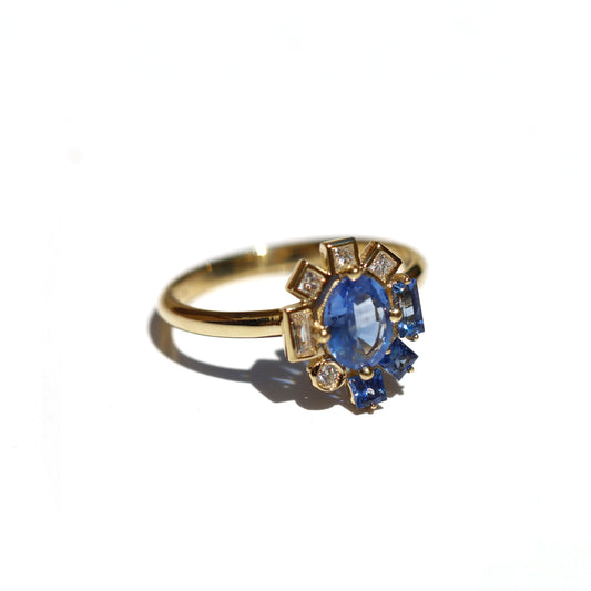 Gold engagement ring with blue sapphire on a white background
