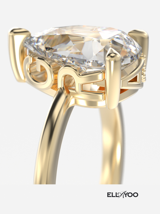 Gold engagement ring with name engraving detail and a large diamond on a white background