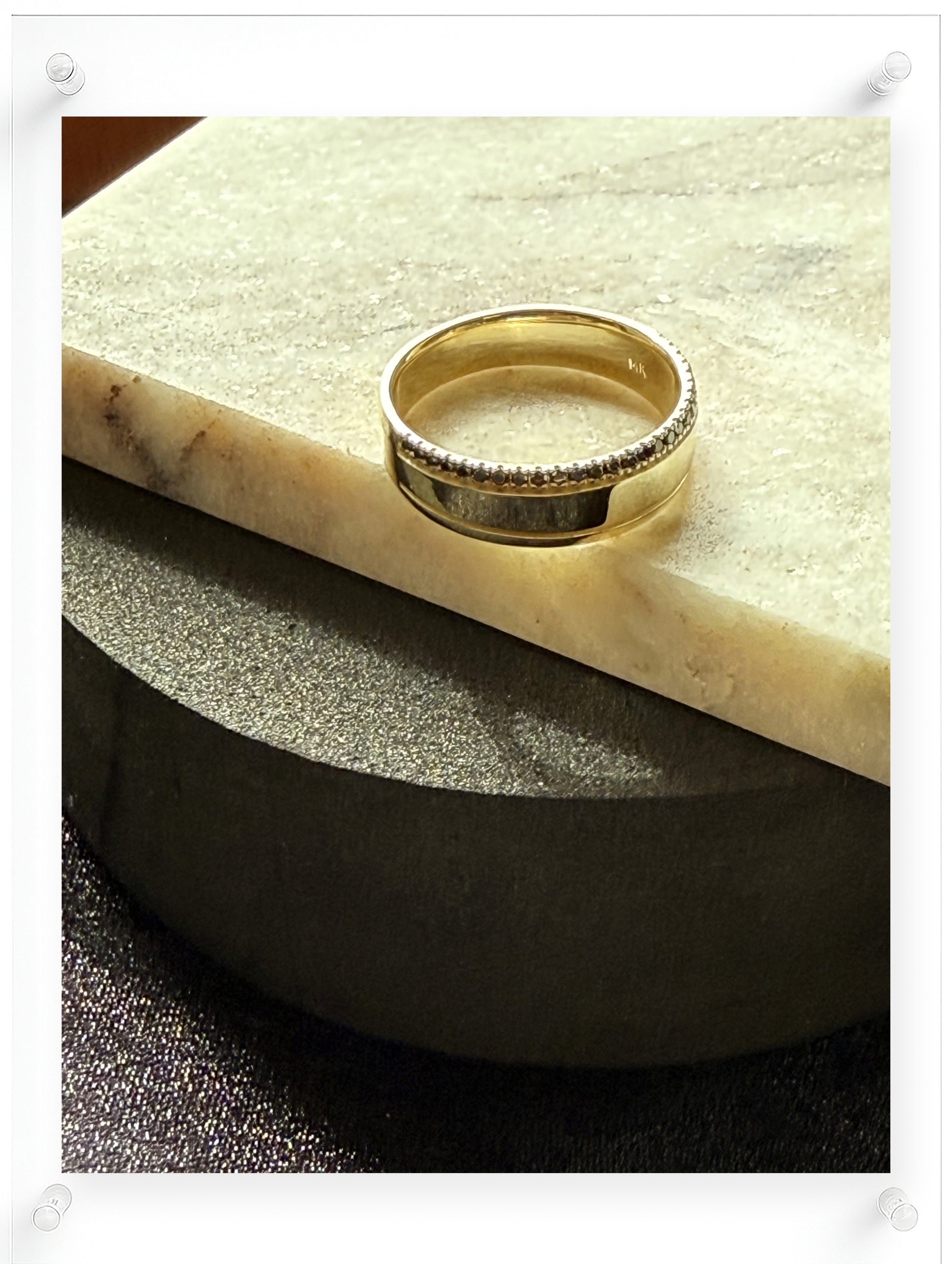 14K yellow gold band ring with black diamond pavé accent on a marble surface, minimalist fine jewelry by Ella Yoo