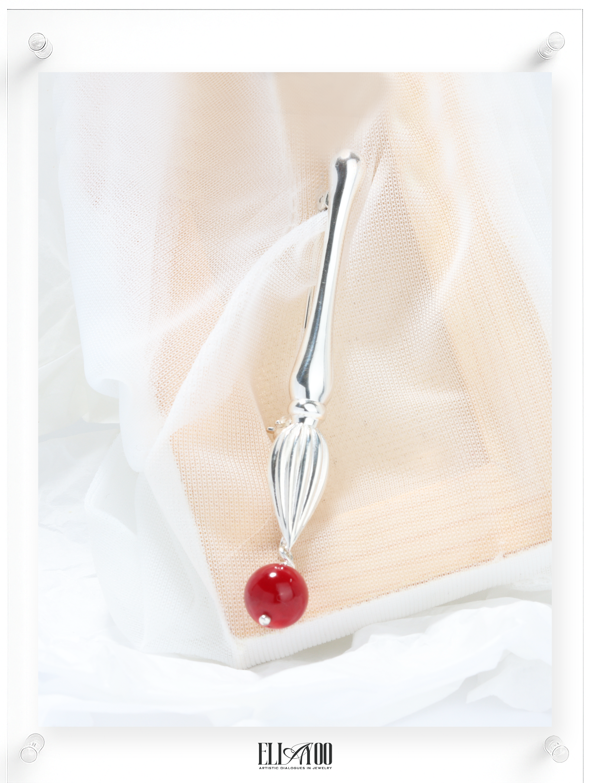 Front view of Silver brooch featuring a paint brush shape with a Coral Sphere