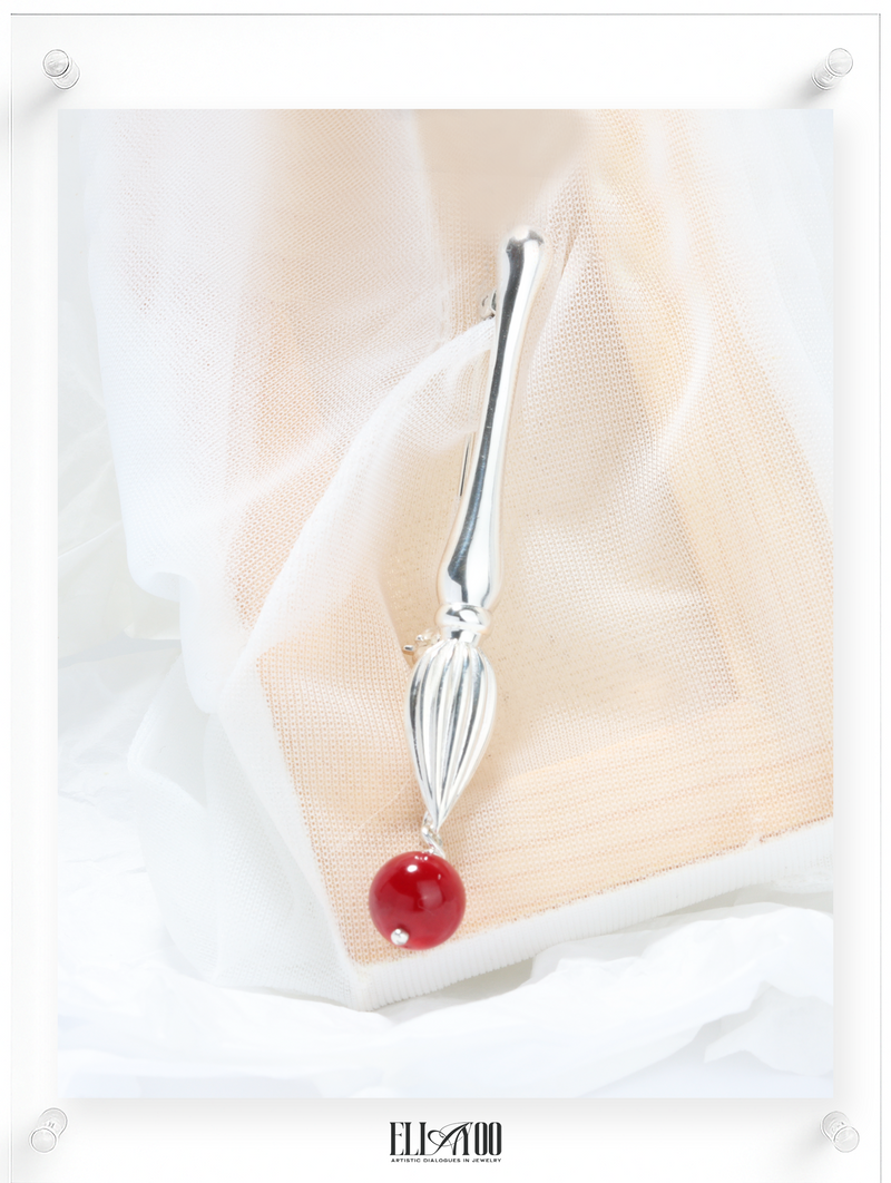 Front view of Silver brooch featuring a paint brush shape with a Coral Sphere