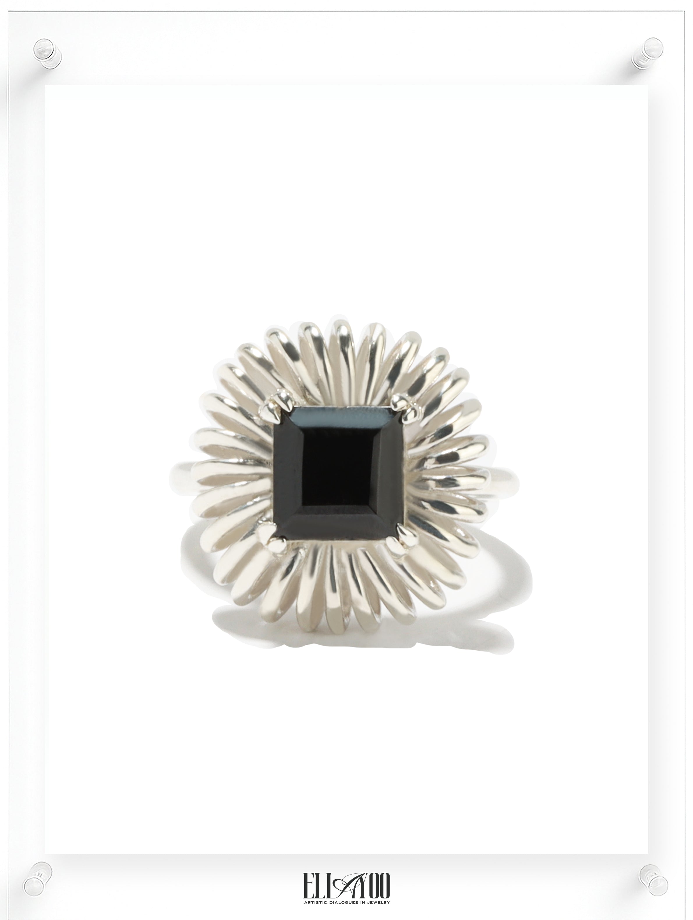 Princess cut onyx ring with sculptural silver petal setting, contemporary art-inspired design
