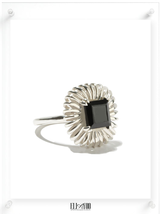 Side view of princess cut onyx ring with sculptural silver petal setting