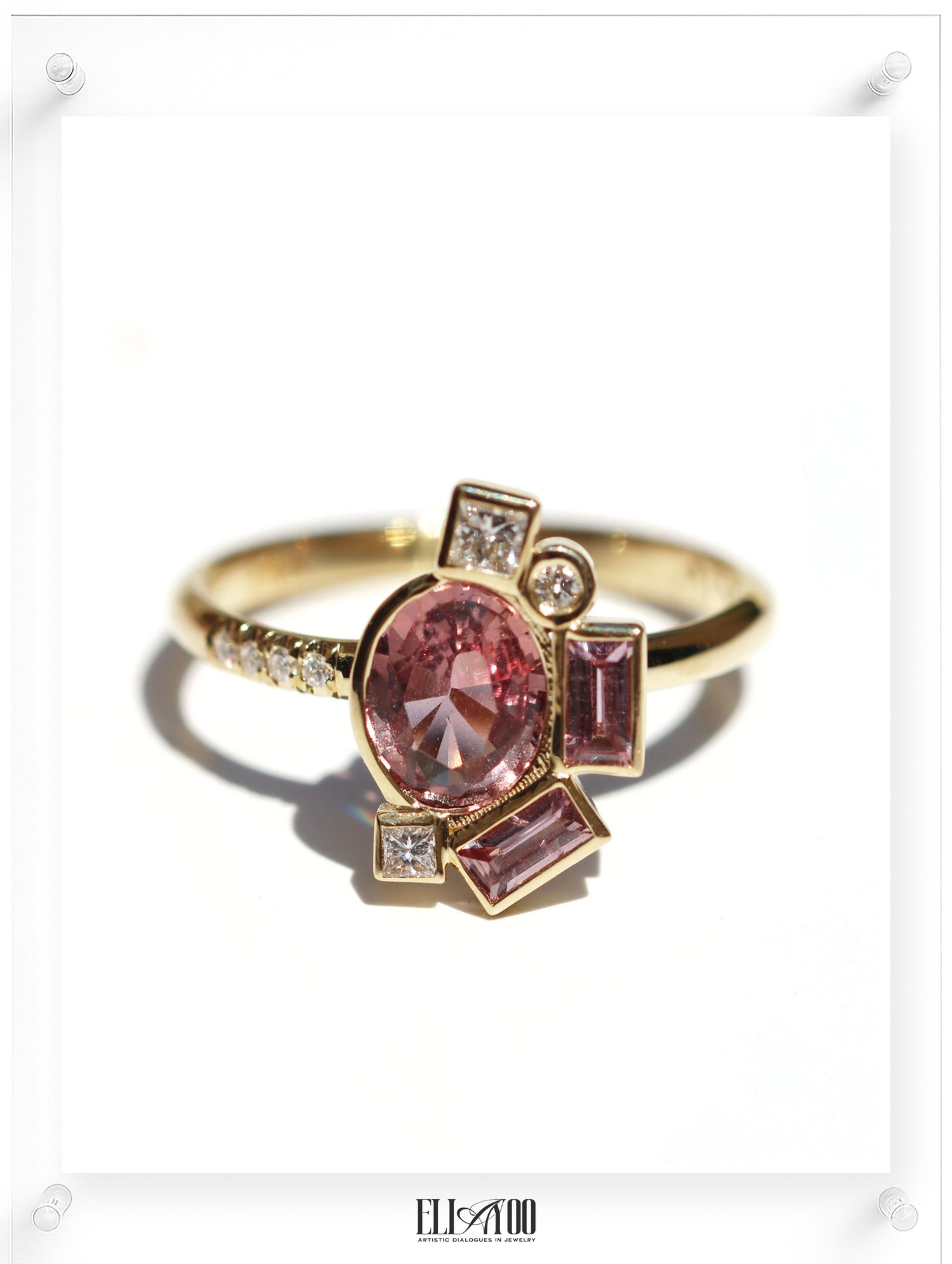 Gold ring with pink gemstones on a white background