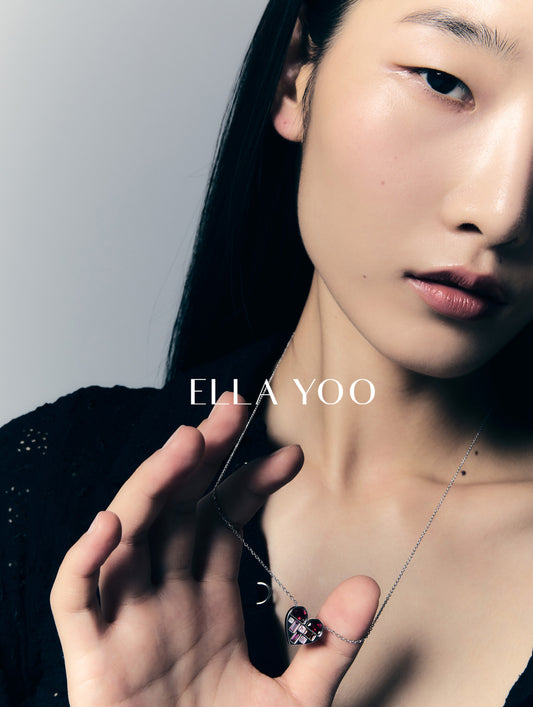 Woman wearing a necklace with 'Ella Yoo' branding on a gray background