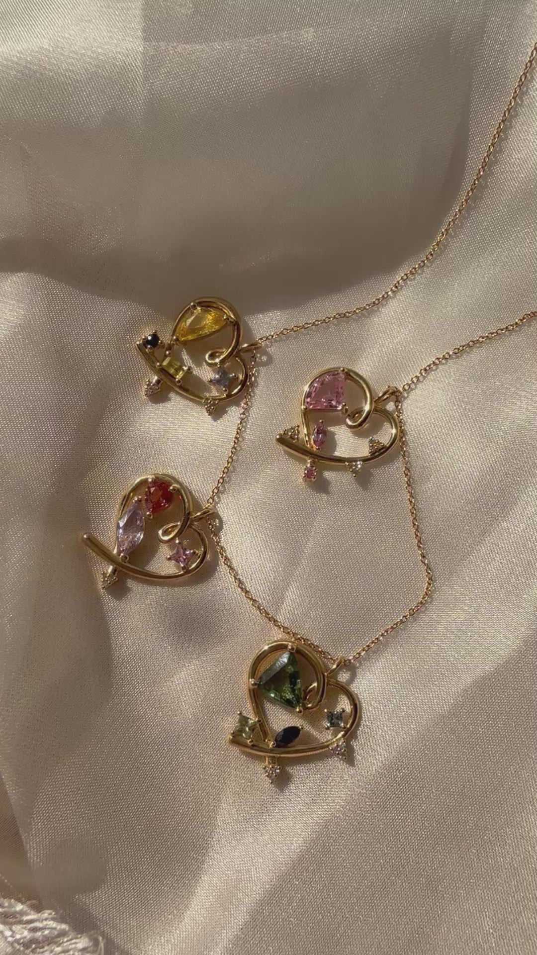 14K yellow gold open heart necklace featuring an asymmetrical pink sapphire and geometric sapphire accents, inspired by Bauhaus design philosophy.