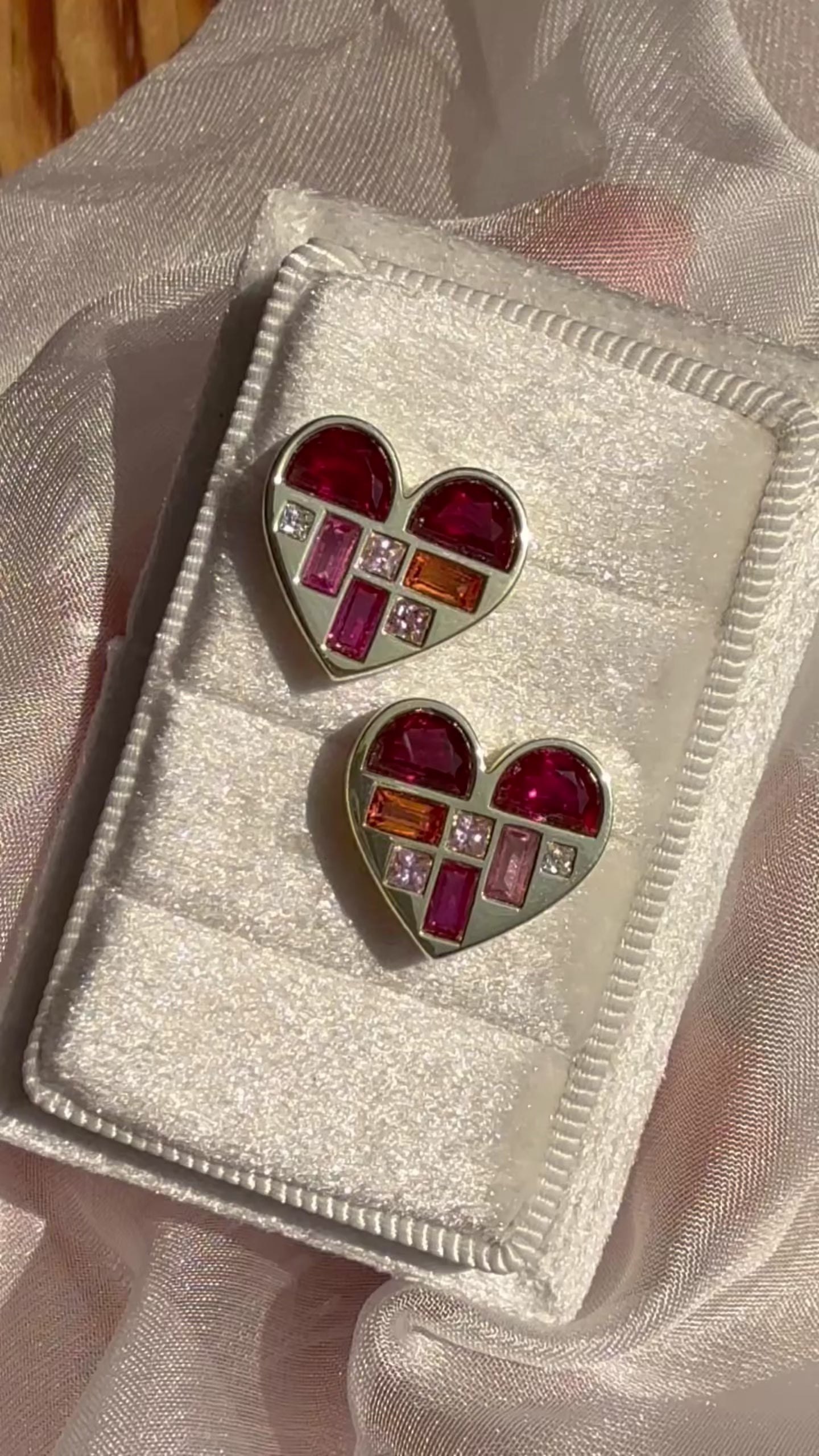 Close-up video of 14K yellow gold heart stud earrings with multicolor gemstones by Ella Yoo Jewelry